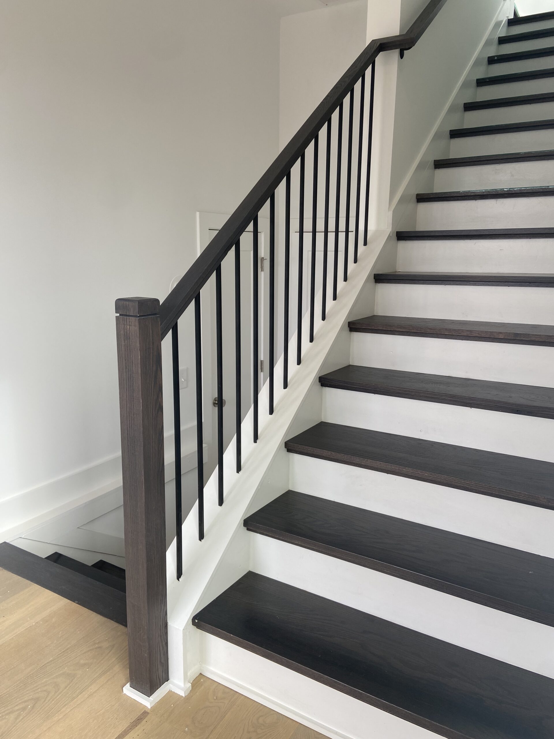 wood and iron stair railing on traditional straight stairs