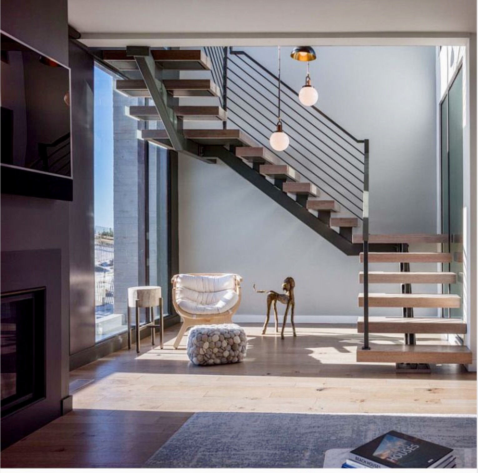 single beam floating stairs with chair and ottoman underneath